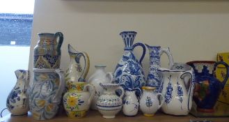 Twelve Portuguese Ceramic Jugs, of various sizes and styles, hand-painted in typical fashion.