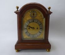 An Edwardian English Striking Bracket Clock, the clock having an oak break arch top case with