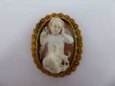 An Antique Shell and Ivory Deeply Carved Cameo Brooch, carved with a putti and puppy in relief,