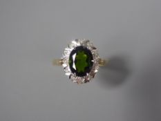 An 18ct Yellow Gold Green Tourmaline and Diamond Ring. The tourmaline measuring approx 9 x 7 mm