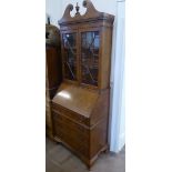 A Burr Walnut Drop-Down Secretaire, with glazed-fronted bookcase to top (two shelves) and four