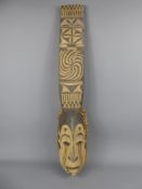 An Oceanic Mask, the mask has a plaited palm frond frame, carved of wood with natural pigments, a