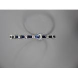 An 18ct White Gold Diamond and Sapphire Bracelet. The bracelet set with 9 princess cut dias,