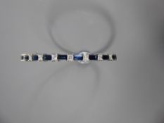 An 18ct White Gold Diamond and Sapphire Bracelet. The bracelet set with 9 princess cut dias,