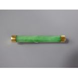 An 18ct Yellow Gold Chinese Apple Green Jade Bar Brooch, approx 5.3 cms and 7.4 gms, character marks
