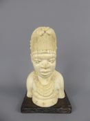 A West African Ivory Bust of a Woman, approx 18 cms, the figure depicted with elaborate headdress,
