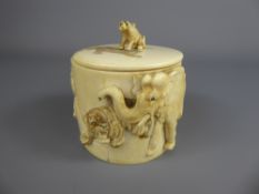 A 19th Century Ivory Cylindrical Pot and Cover, deeply carved with tigers hunting elephant, approx 7