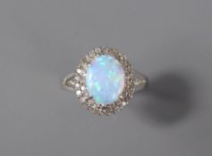 A 9ct White Gold Diamond and Opal Ring. The opal measuring approx 10 x 8 mm and surrounded by approx