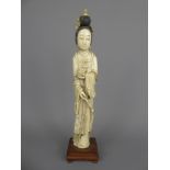 A 19th Century Ivory Okimono, finely carved as a Geisha depicted standing in long robes holding a