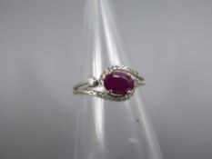 An 18 ct White Gold Ruby and Diamond Ring, the oval ruby 7.5 mm, approx 14 pts of das, size N,