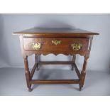 An Antique Oak Side Table, the table having one central drawer with brass swan-neck handles and lock