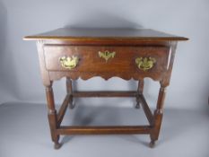 An Antique Oak Side Table, the table having one central drawer with brass swan-neck handles and lock