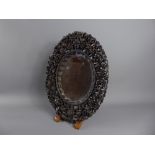 An Antique Chinese Carved Oval Mirror, intricately carved with figures and pagoda.