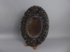 An Antique Chinese Carved Oval Mirror, intricately carved with figures and pagoda.