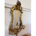 An Early 19th Century Rococo Gilt-Wood Mirror, the frame having carved foliate decoration with two
