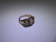 An Antique Style 9 ct Gold Opal and Sapphire Ring,one 7 x 3 mm opal, two 6 x 4mm opal, 4 x 1.5 mm