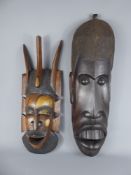 A 1976 Tanzanian Iron Wood Carved Mask, approx 65 x 20 cms, together with a wood carved mask. (2)