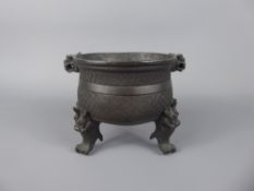 An Antique Chinese Bronze Censer, tripod base with incised motif decoration, mask handles with