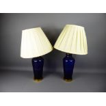 A Pair of Bristol Blue Glass and Brass Lamp Bases with cream shades, approx 41 cms high.