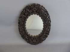 An Antique Oval Chinese Hardwood Mirror, intricately pierced and carved with Chinese figures and