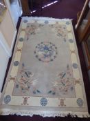 A Washed Chinese Wool Carpet depicting dragons and flowers to centre and at each corner, on a grey