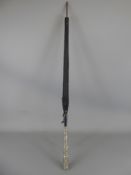 An Elegant Victorian Silver Topped Black Parasol. The parasol fabric depicting gold lilies and the