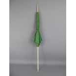 An Antique Ivory Handled Parasol, of green moire silk, approx 85 cms, the handle and finial carved