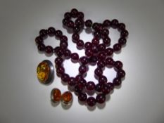 A Set of Dark Red Amber Beads, approx 11 mm, approx 82 cms, approx 70 gms together with a pair of