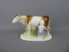 A Porcelain Figurine of a Girl milking a cow, marks to base WA GDR NR 861, approx 21 x 13.5 cms.