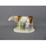 A Porcelain Figurine of a Girl milking a cow, marks to base WA GDR NR 861, approx 21 x 13.5 cms.