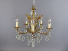 A Pair of Gilded-Brass Chandeliers with five twisted arms and bulbs and decorated with cut-glass