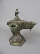 A 13th Century Khorassan Bronze Double Spouted Oil Lamp, with hinged bird cover on a hexagonal base.