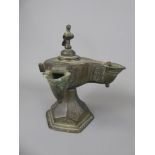 A 13th Century Khorassan Bronze Double Spouted Oil Lamp, with hinged bird cover on a hexagonal base.