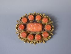 An Antique Chinese Style 15/18ct Yellow Gold and Coral Brooch, the brooch set with a central