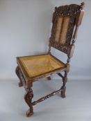 A Jacobean Style Carved Oak Hall Chair. The chair having a cane back and set with a carved cherub