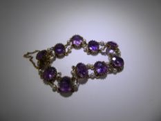 A Vintage 9ct Gold Amethyst and Pearl Bracelet, set with ten oval amethyst with pearl links,