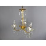 A Pair of Gilded-Brass and Glass Chandeliers with three twisted arms and bulbs and decorated with