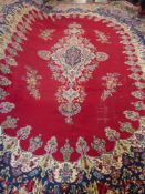 A Large 20th Century Persian Wool Carpet, primarily ruby and cobalt blue ground of foliate design,