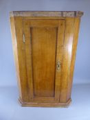 An Antique Oak Hanging Corner Cupboard with brass key plate (key missing) revealing two internal