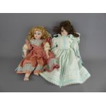 Two Lillian Miller Bisque-Headed Dolls, dressed in cotton dresses, together with a small quantity of