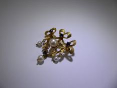 A 9ct Yellow Gold Sapphire & Pearl Brooch. The shield form brooch decorated with ribbon swags and