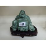 ORIENTAL GREEN HARDSTONE FIGURE OF A SEATED BUDDHA ON A WOODEN BASE 17 CMS