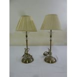 A pair of metal and glass table lamps on raised circular bases with silk shades