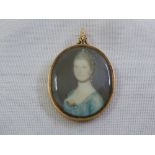 A Georgian miniature portrait pendant of a lady in period costume mounted in gold frame