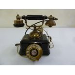 An antique style telephone with revolving dial and central bell