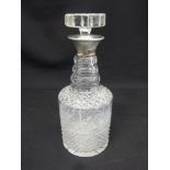 A cut glass decanter with drop stopper and plain silver collar