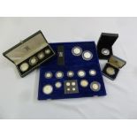 A quantity of silver coins in fitted cases to include £5s and Maundy money