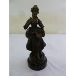 A bronze figurine of a lady in 18th century dress on a circular marble plinth, 33cm (h)