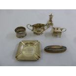 A quantity of silver to include a condiment set, a silver mounted nail buff, an ashtray and a napkin