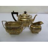 A silver three piece bachelor teaset part fluted on ball feet, Sheffield 1902